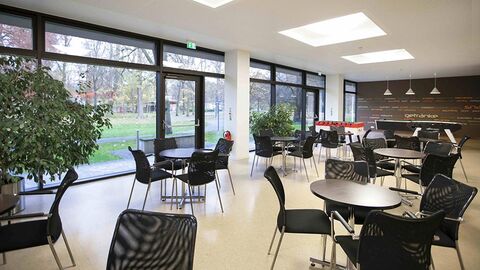 Cafeteria Raum mit runden Tischen und Stühlen