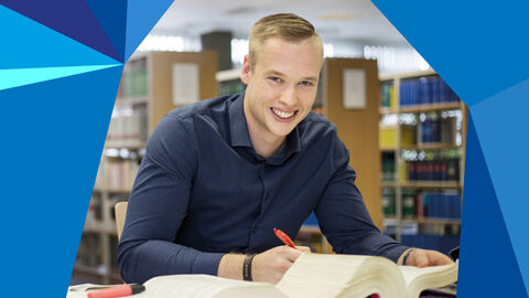 Amtsanwalt Junger Mann am Schreibtisch mit Buch vor sich und Stift in der Hand